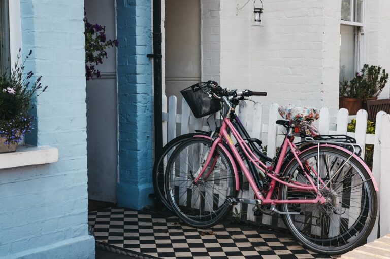 Sein und ihr Fahrrad vor einem pastellblauen Haus in Barnes, Lo