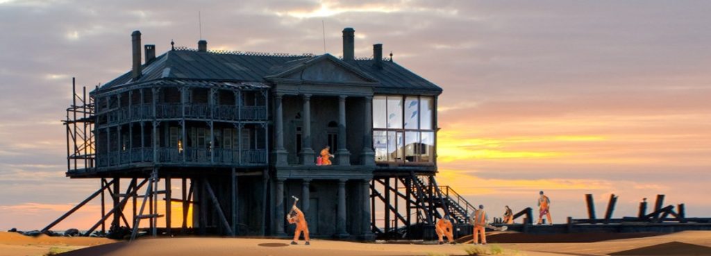 Mehrere Bauarbeiter bauen ein Haus am Strand